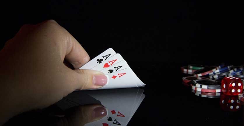 hand holding four aces