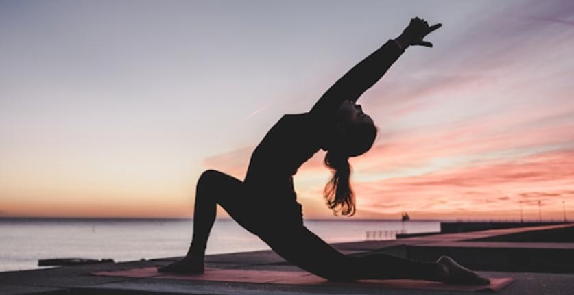 woman practicing yoga at dawn